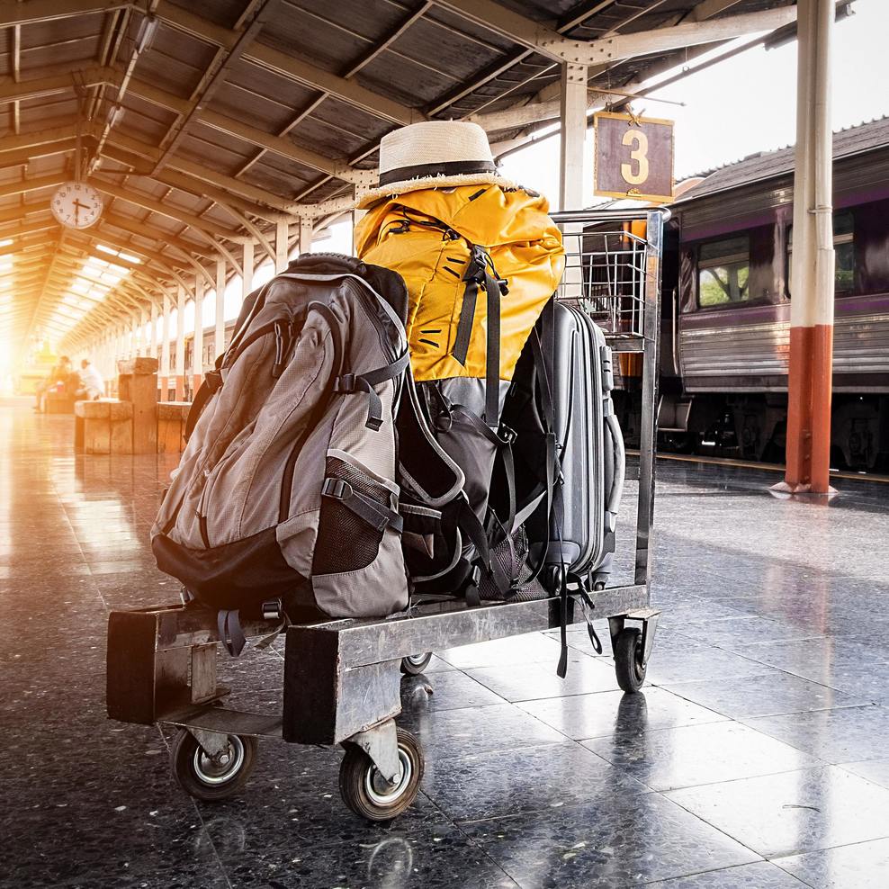 A car with various pieces of luggage stands on a track in the station.