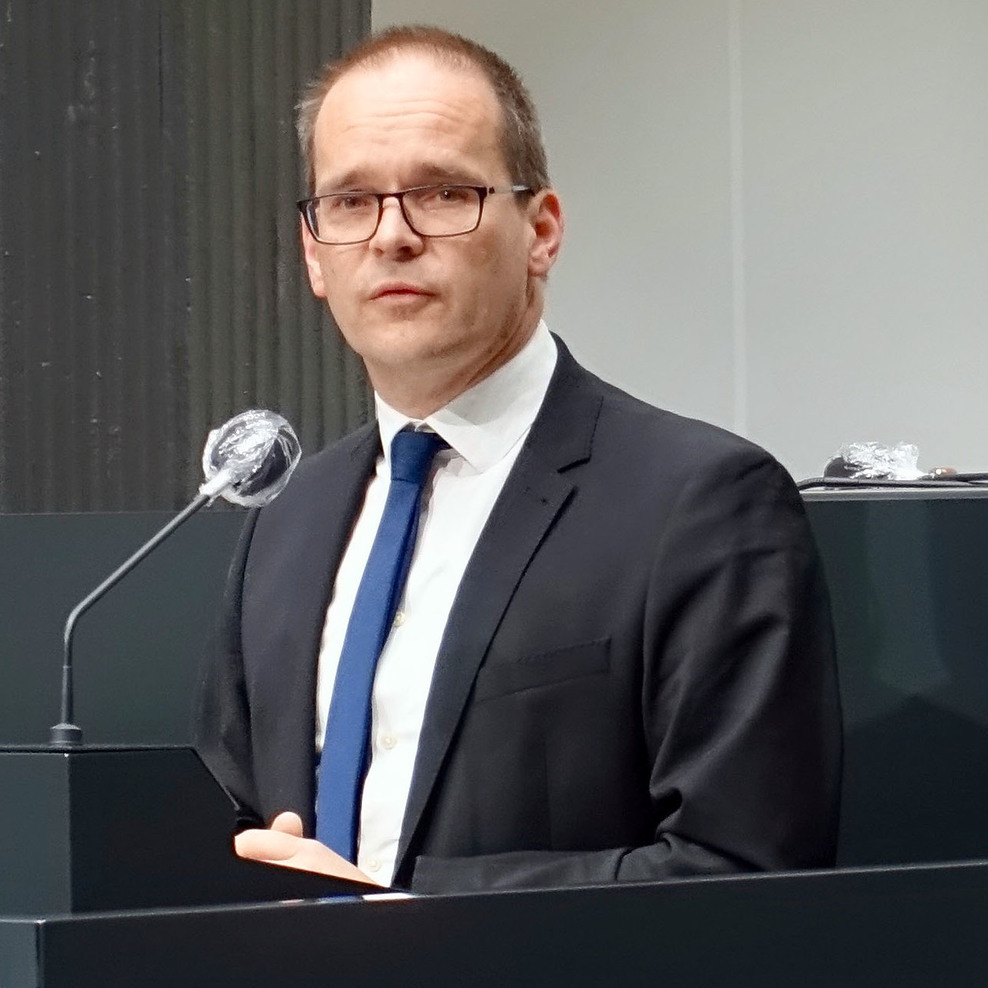 Kultusminister Grant Hendrik Tonne in der Pressekonferenz des Corona-Krisenstabs mit einer Gebärdendolmetscherin neben sich.