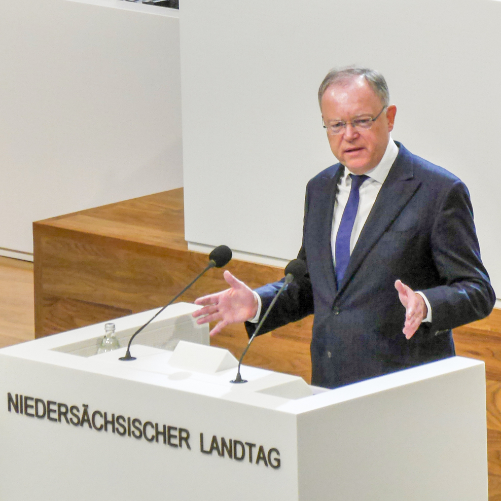 Ministerpräsident Stephan Weil steht gestikulierend hinter einem Rednerpult, das die Inschrift "Niedersächsischer Landtag" trägt.